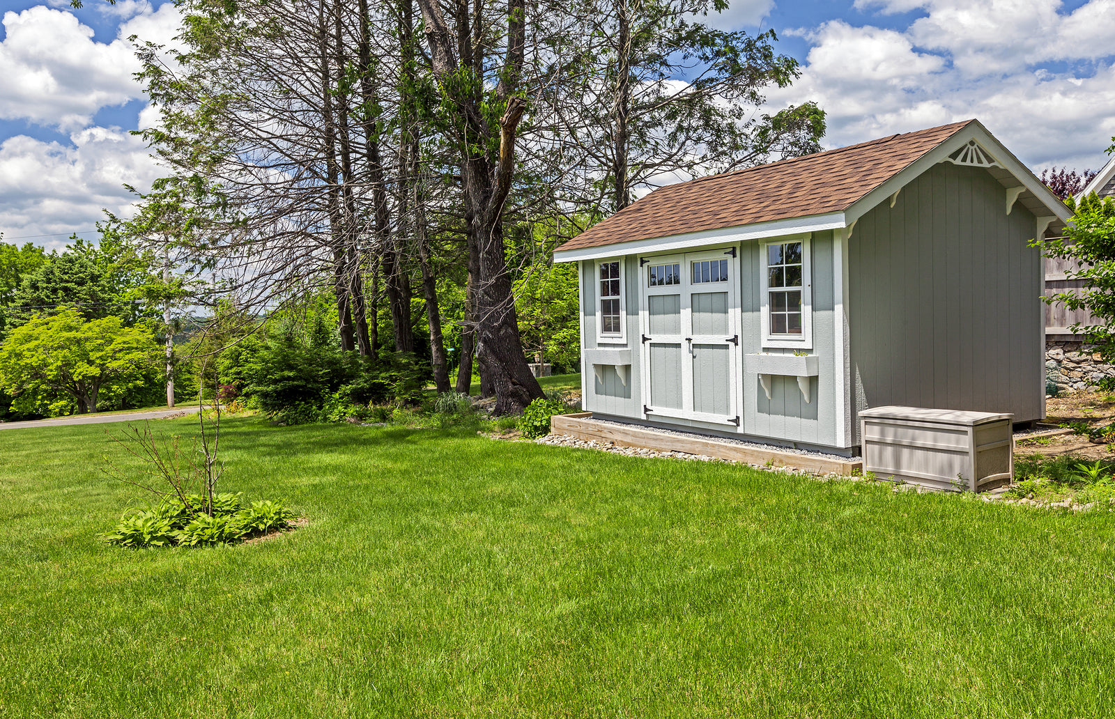 A background image featuring a gorgeous shed in a spacious yard