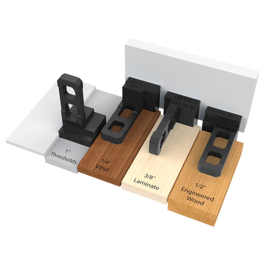 Four black measuring tools are placed on different flooring types—thresholds, vinyl, laminate, and engineered wood—displaying height differences of 1, 1/4, 3/8, and 1/2 inches next to a white wall. This setup emphasizes the importance of accurate measurements when installing laminate flooring with the Roberts Pro Flooring Installation Kit to ensure smooth transitions between surfaces.