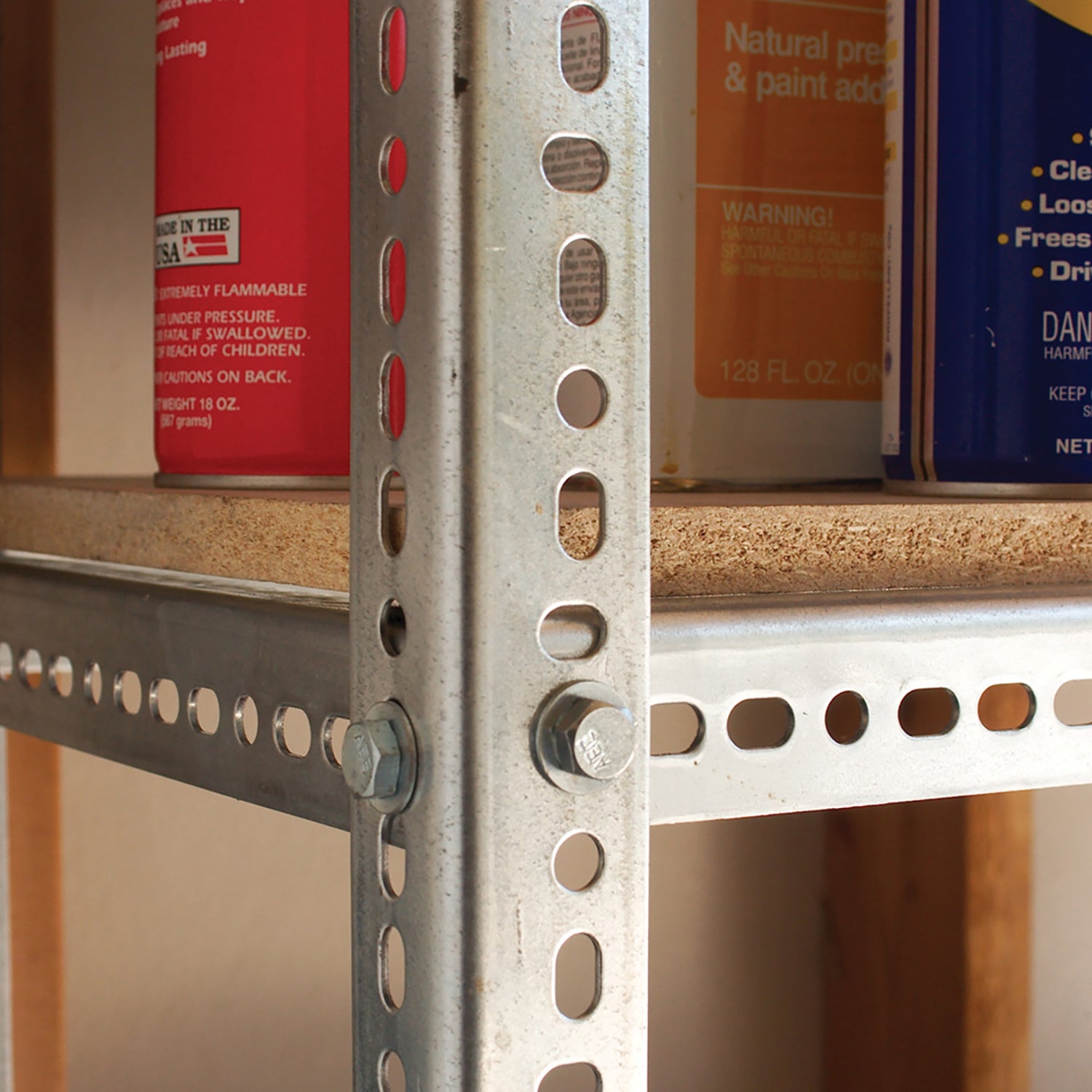 A heavy-duty 1-1/2″ x 48″ Zinc Plated Steel Angle post is bolted to a metal shelf unit holding various household containers.