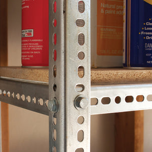 A heavy-duty 1-1/2″ x 48″ Zinc Plated Steel Angle post is bolted to a metal shelf unit holding various household containers.