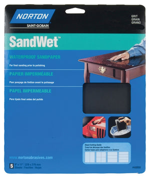 A Norton Very Fine 220 Grit Paper Sheet package with aluminum oxide abrasive is shown sanding wood by hand. Text appears in English, French, and Spanish; smaller images illustrate sanding a car and another item.