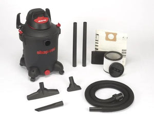 Photo of a black shop-vac vacuum with included accessories on a white background