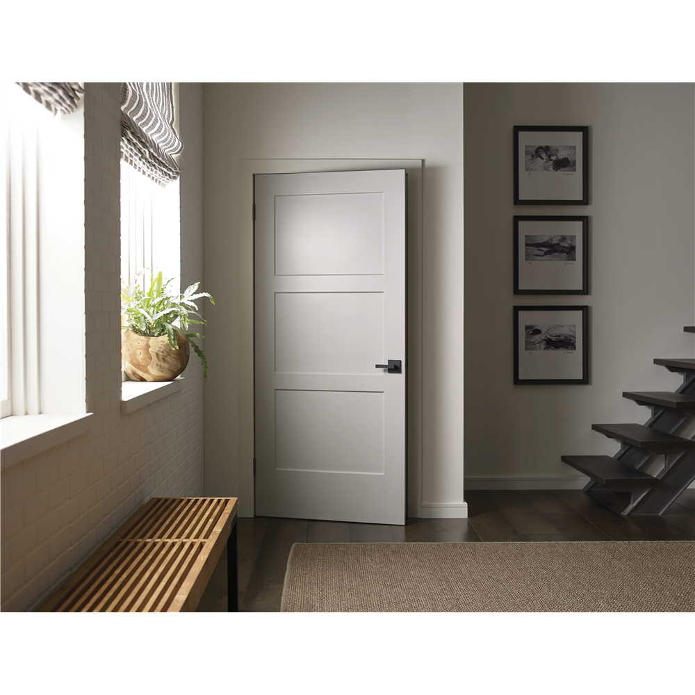 White three panel Metrie Birkdale door with black hardware slightly open into a closet accompanied by home decor and a staircase.