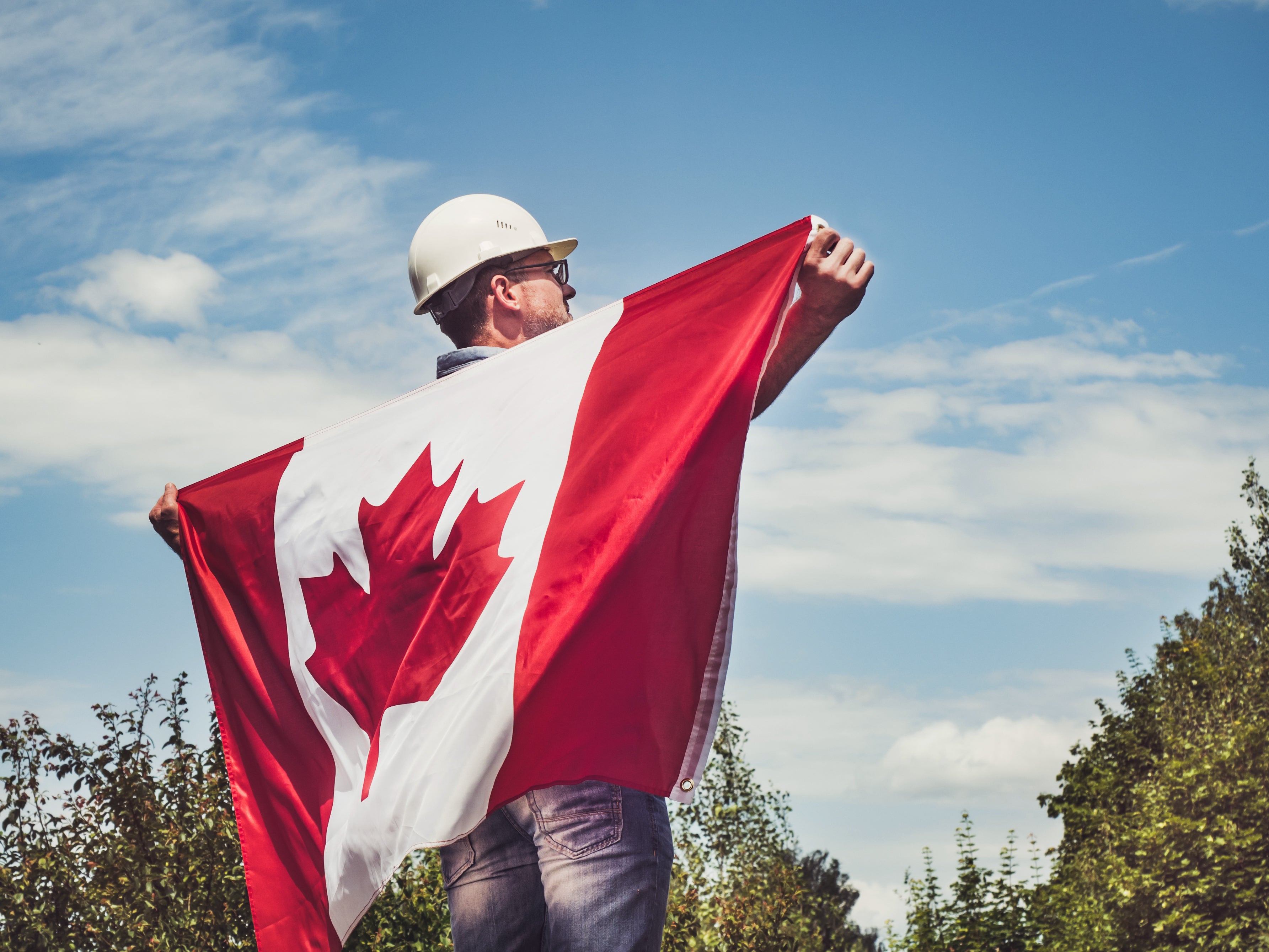 A Builder/ Contractor holding a Canadian Flag