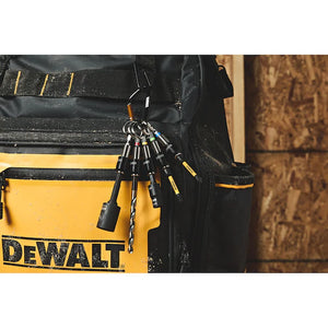 A close-up of a DEWALT tool bag featuring the Dewalt Quick Access Keychain Bit Holder 5 Sleeve with several drill bits attached to the front pocket, set against a wooden background.