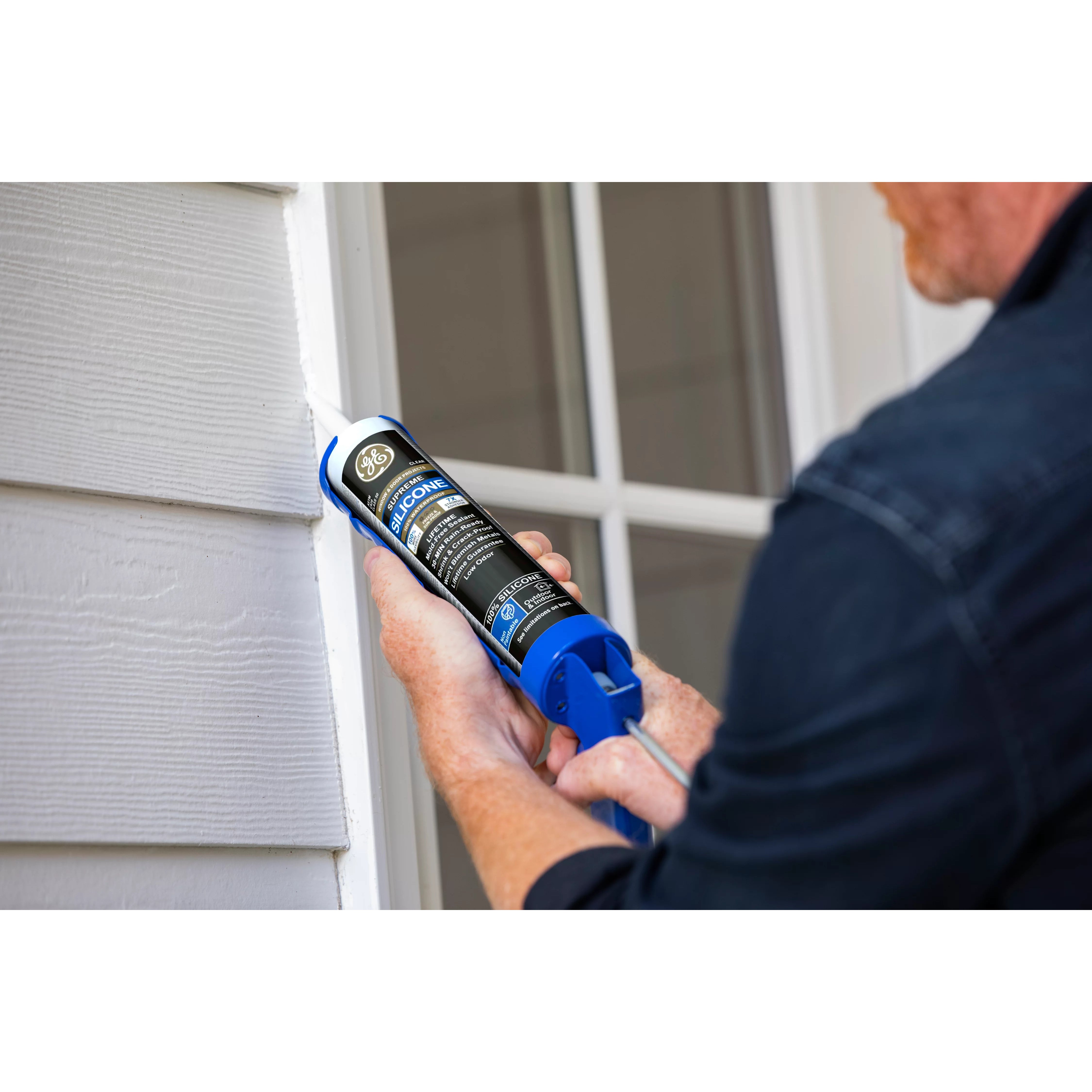 Person applying silicone sealant to a window frame