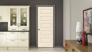 A modern kitchen features cream cabinets, a Jeld-Wen 12"x80"x1-3/8" Rockport 5-Panel Smooth Slab door, a dark gray wall, and a side table displaying decorative vases, a framed picture, and a red pepper grinder.