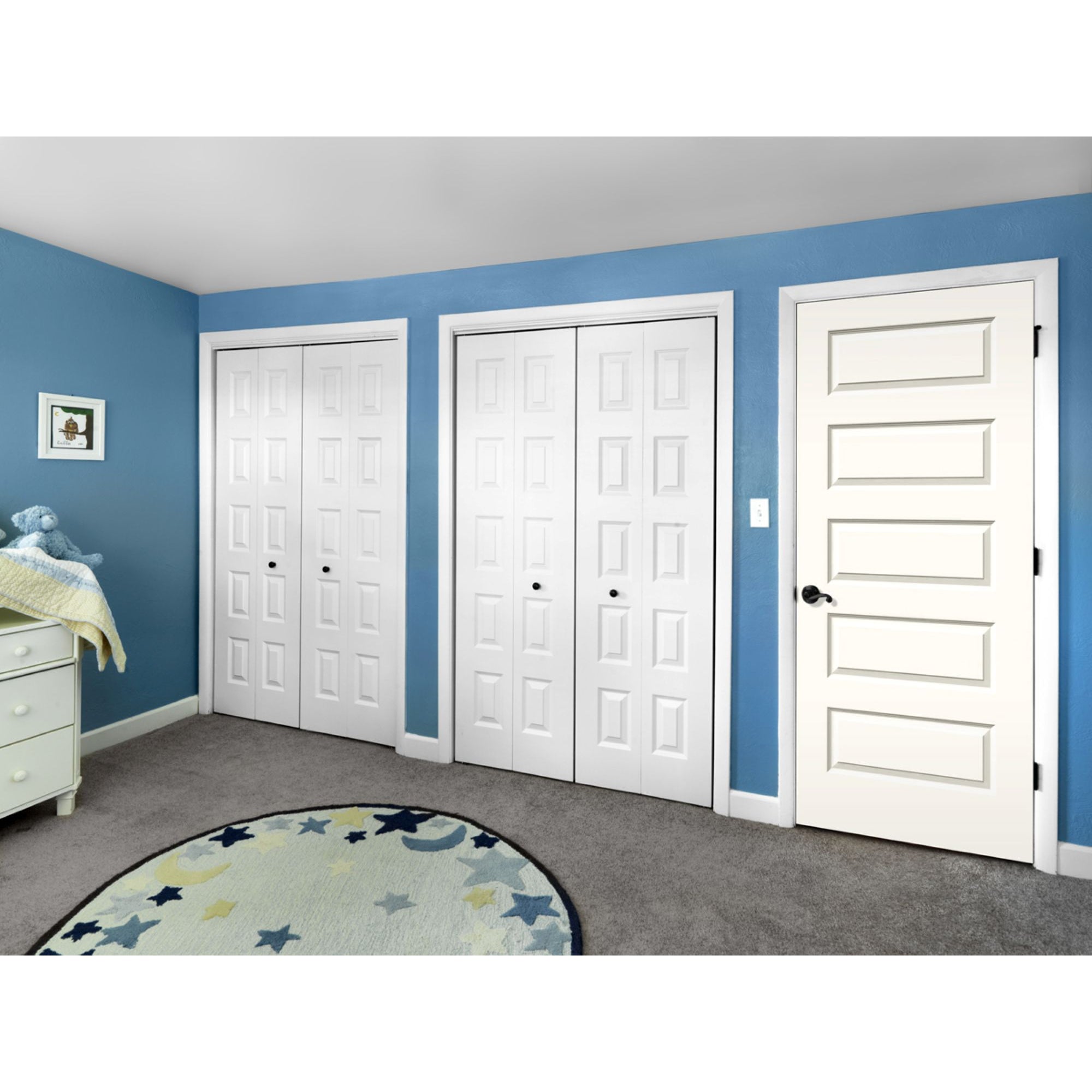 A blue-walled bedroom with gray carpet, two white double-door closets, a Jeld-Wen 12"X80" Rockport 5-Panel Smooth Slab door, a star round rug, dresser, and changing table with a stuffed blue animal and blanket.
