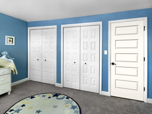 A blue-walled bedroom with gray carpet, two white double-door closets, a Jeld-Wen 12"X80" Rockport 5-Panel Smooth Slab door, a star round rug, dresser, and changing table with a stuffed blue animal and blanket.