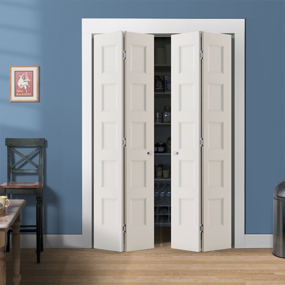 A Jeld-Wen 24"X80"X1-3/8" Conmore 5-Panel Recessed Bifold door in white is partially open in a blue-walled room with light wood floors, showing shelves inside and nearby a chair, small table, framed poster, and metal trash can.