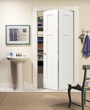 A Jeld-Wen 24"X80"X1-3/8" Craftsman 3-Panel Recessed Bifold closet door stands open to show shelves with towels and baskets. A pedestal sink with mirror is on the left, and a green chair with a towel is on the right in this tidy bathroom.