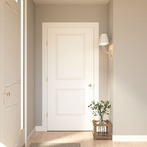 A minimal entryway with light beige walls, a Jeld-Wen 24"X78"X1-3/8" Carrara 2-Panel Square Smooth Slab door, wall-mounted lamp, engineered wood floors, and a small potted plant on a wooden stand. Natural light brightens the space.
