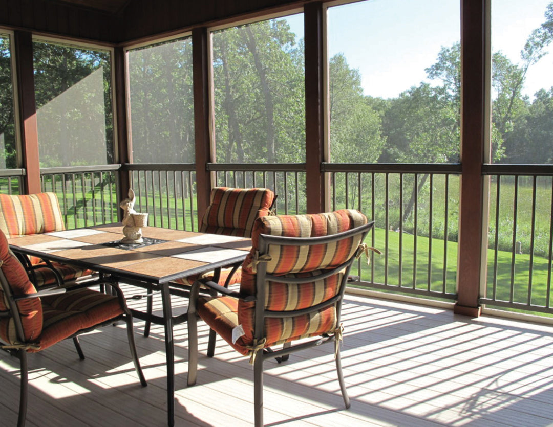 Regal railing built into a sun room atop a composite deck with patio furniture