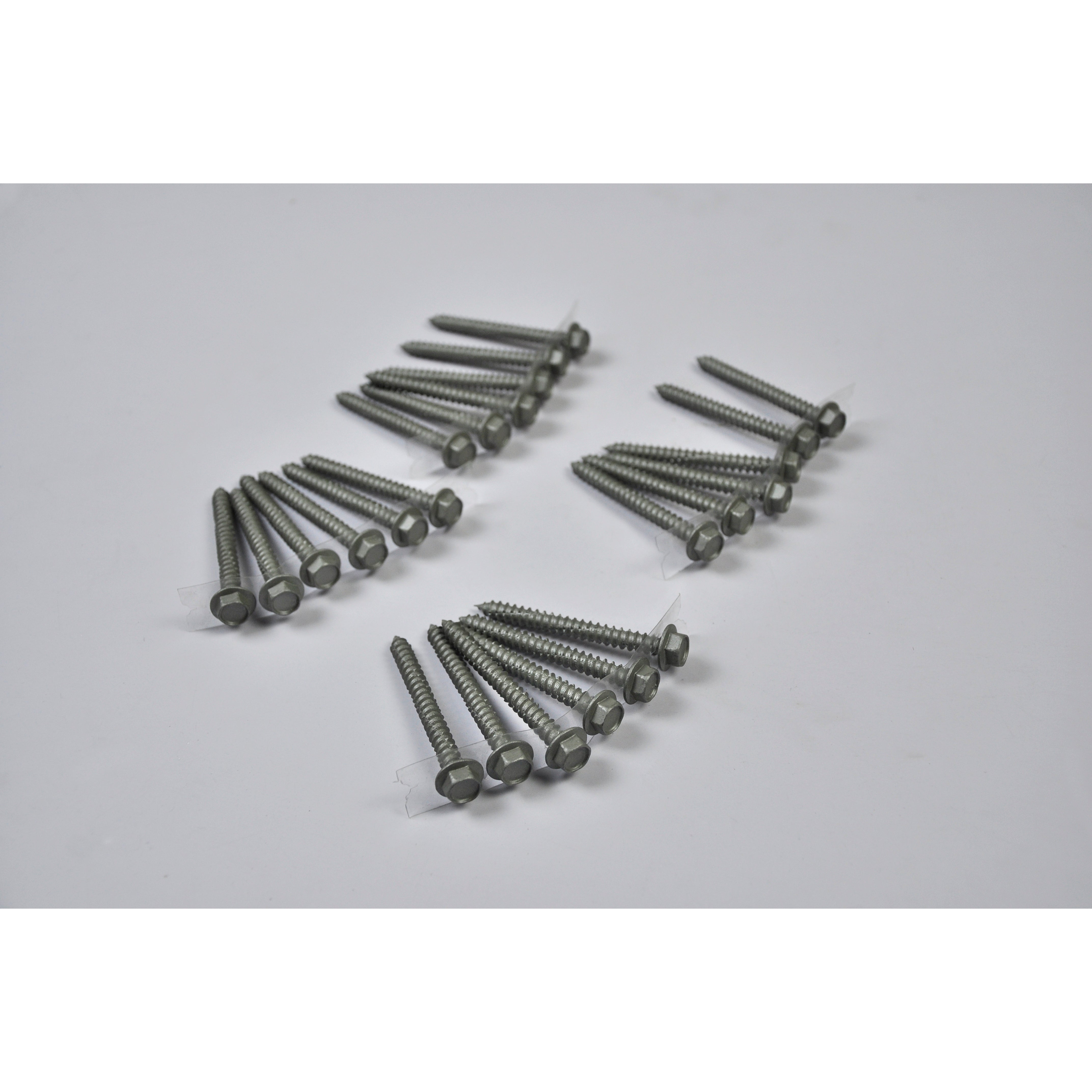 Four groups of Regal Rail 2-1/2" Lag Screws, Titanium Slate (24 pieces), are arranged on a white surface in a symmetric pattern—ideal for aluminum railing systems or mounting rail components.