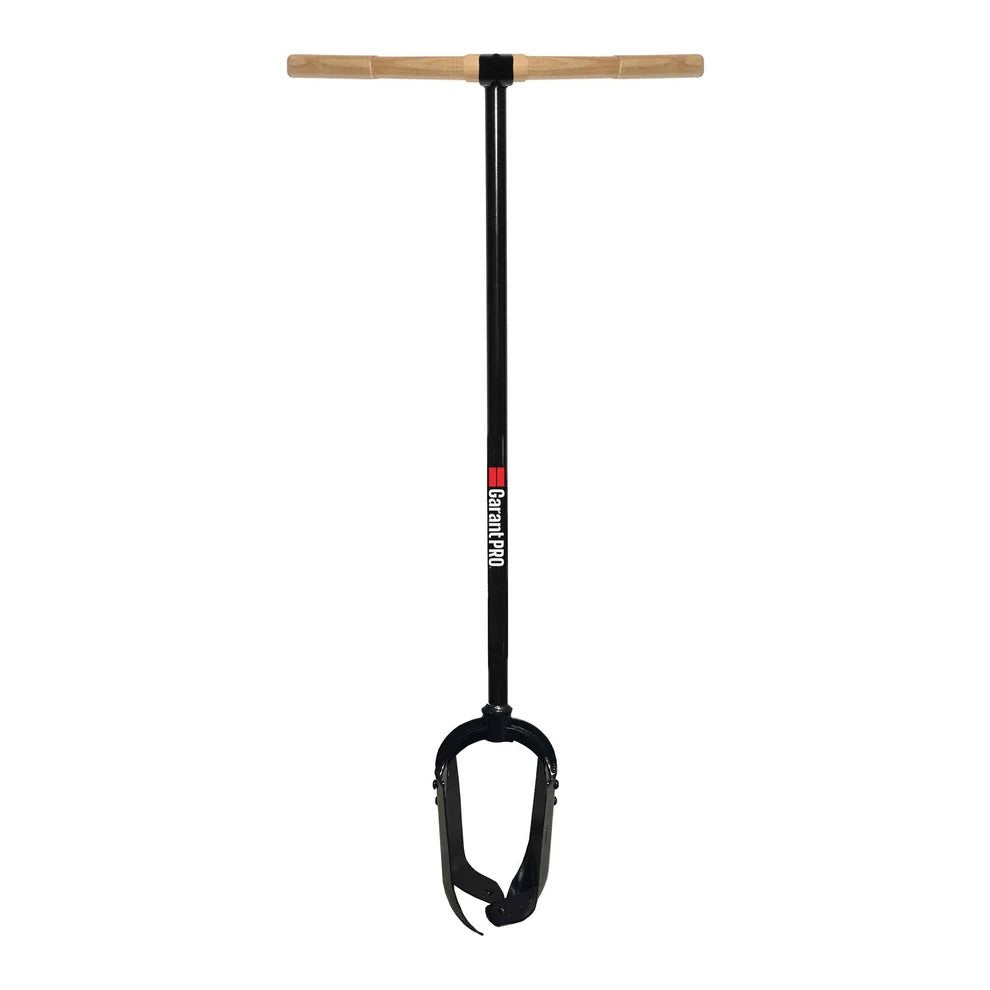 Garant Inc Post Hole Digger with a T-shaped wooden handle and a black steel digging blade shaft featuring two hinged blades at the bottom.