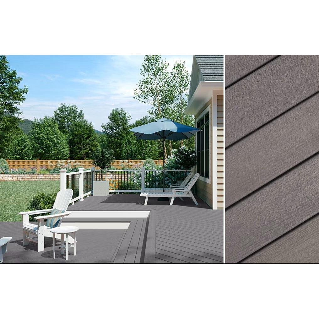 A backyard deck features 1" x 12" x 12' Trex Enhance Basics Pebble Beach boards from Trex, arranged diagonally with white patio furniture, a blue umbrella, and views of trees and a lawn in the background.