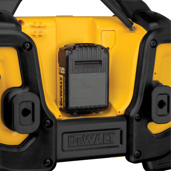 DeWalt radio charging a DeWalt battery pack on a white background