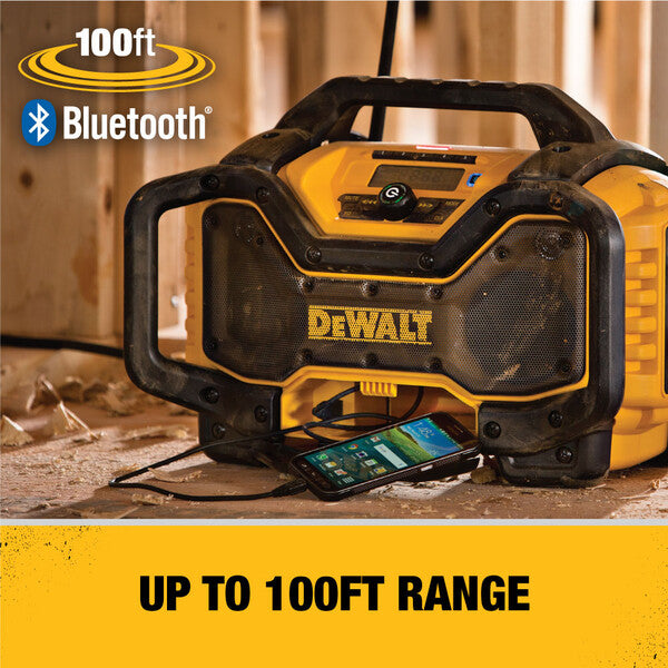 DeWALT Bluetooth radio on a wooden surface with a smartphone connected, featuring '100ft Bluetooth' text.