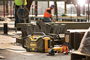 DeWalt radio charging a tool on a construction site with workers in the background